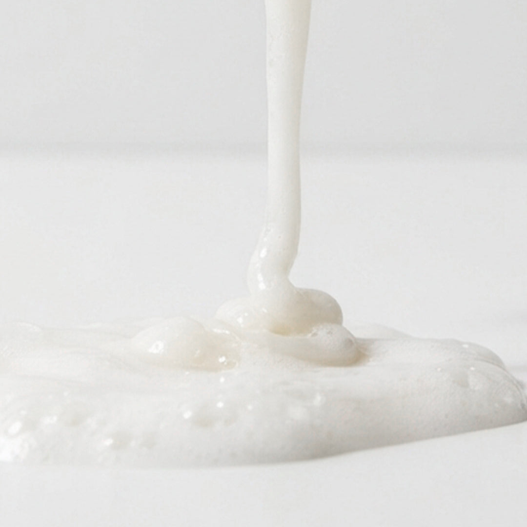 Textura do Shampoo Umo Hair deep repair em fundo branco. Fio corrido de xampu com cor branca e textura leitosa.